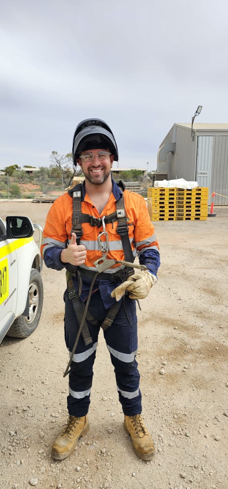 Cobi Rontaunay on site in hi-vis and a safety harness, giving a thumbs up