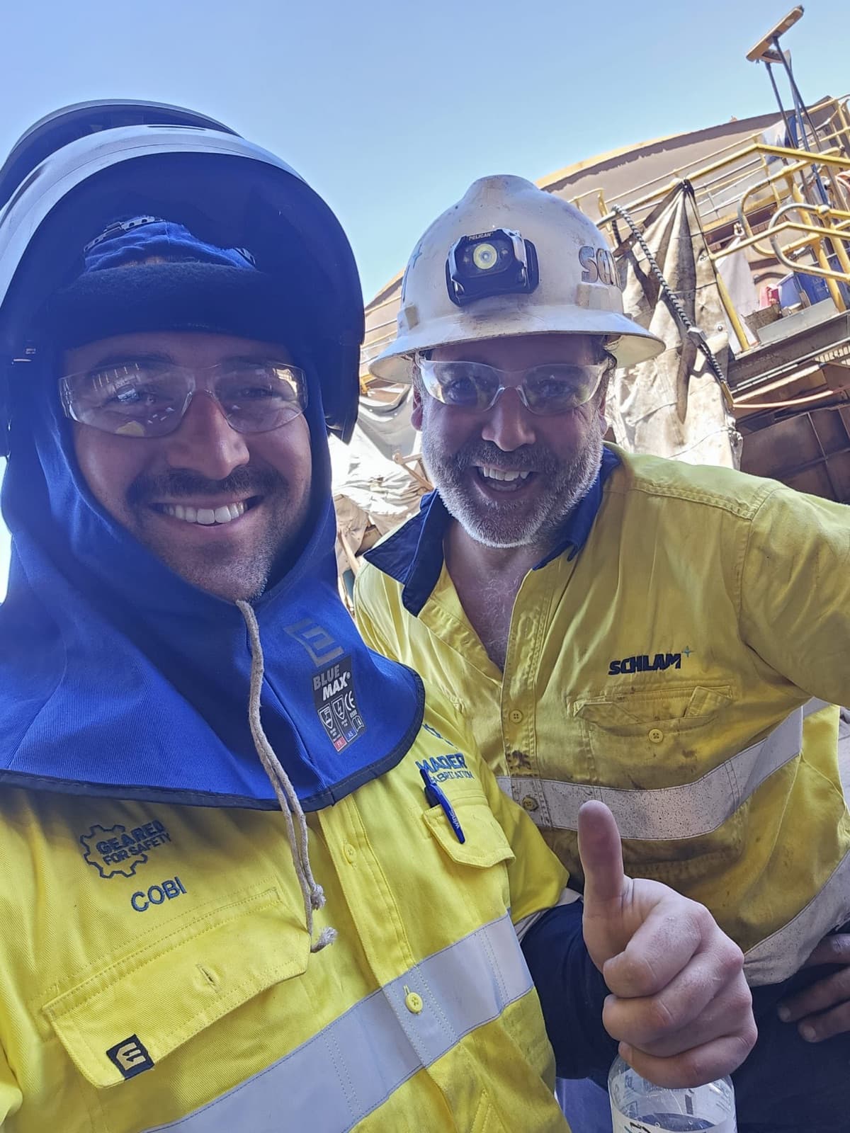 Cobi Rontaunay and a workmate in hi-vis on a mine site, smiling